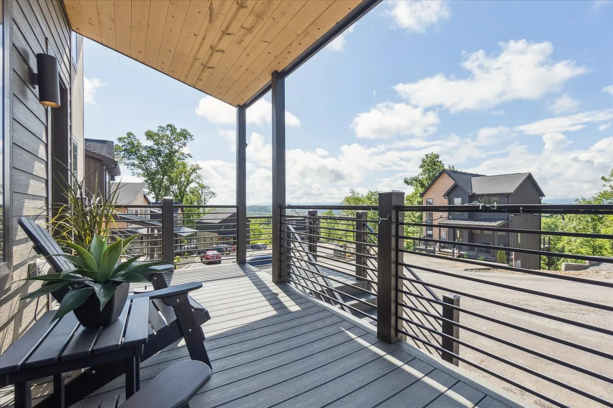 A spacious deck surrounded by trees, outfitted with comfortable outdoor furniture. The area is designed for relaxation, entertaining, or simply enjoying the views and fresh air.